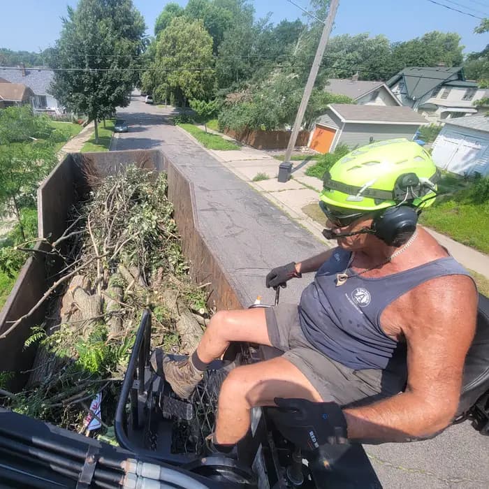 An A Tree Service crew member clearing storm debris from an aerial bucket in the Twin Cities